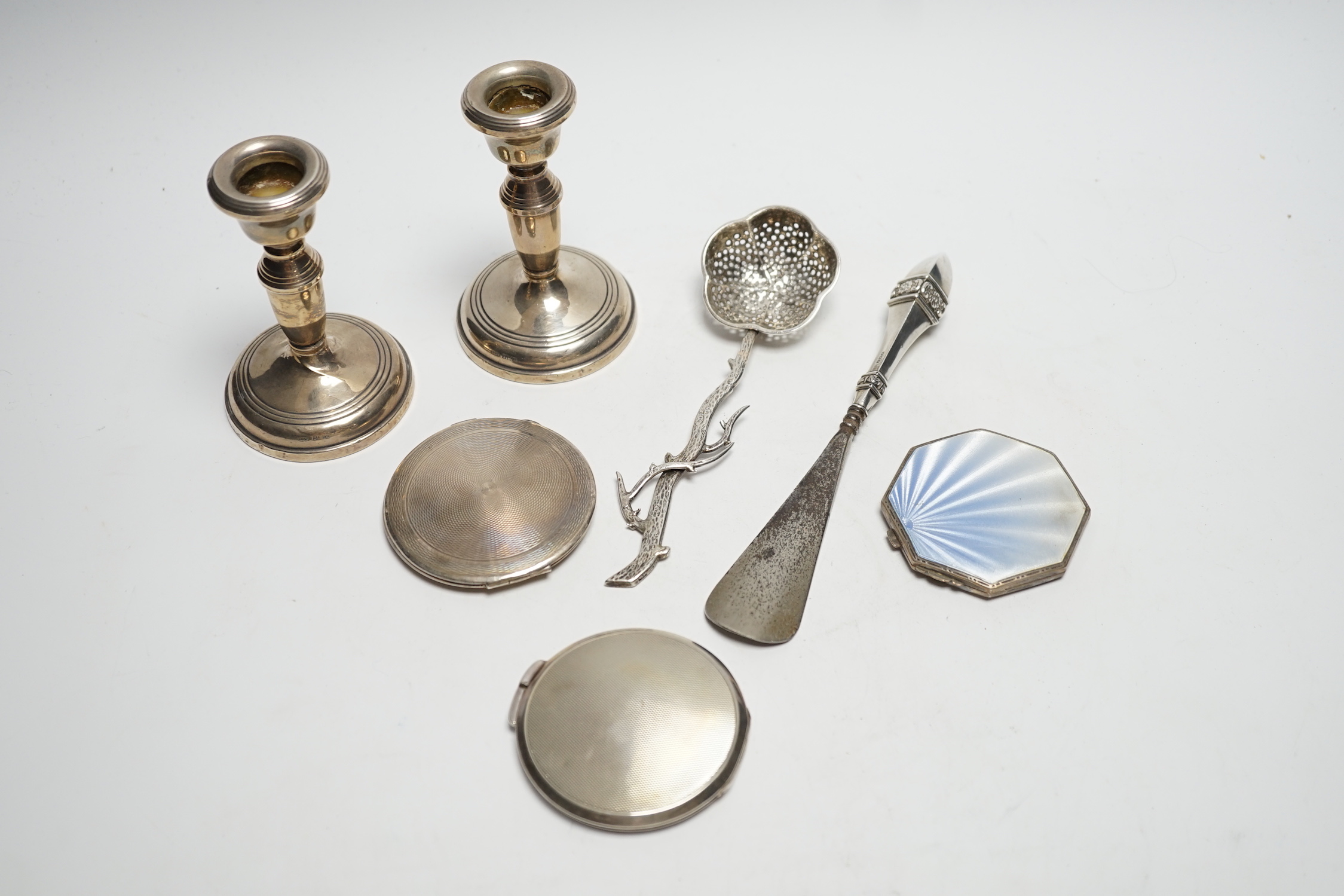 Three silver compacts including one enamelled, a pair of silver mounted dwarf candlesticks, 10.2cm and two other items.